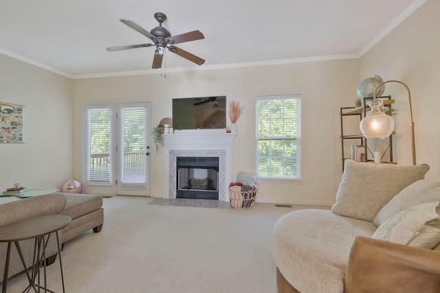 living room featuring carpet, ornamental molding, a fireplace, and a wealth of natural light