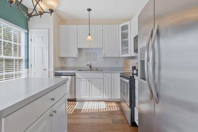 kitchen with white cabinets, sink, dark hardwood / wood-style floors, tasteful backsplash, and stainless steel appliances