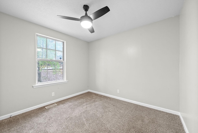 carpeted spare room with ceiling fan and a textured ceiling