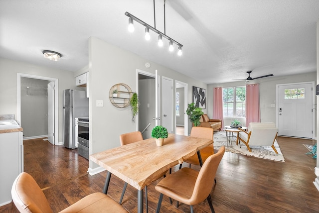 dining room featuring a textured ceiling, ceiling fan, and dark wood-type flooring