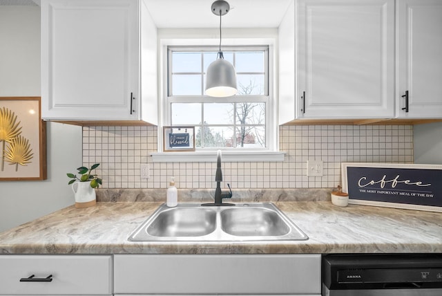 kitchen with pendant lighting, white cabinets, sink, tasteful backsplash, and dishwashing machine