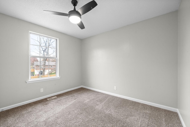 spare room with carpet flooring, ceiling fan, and a textured ceiling