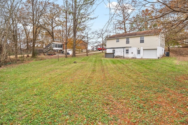 view of yard with central AC and a garage