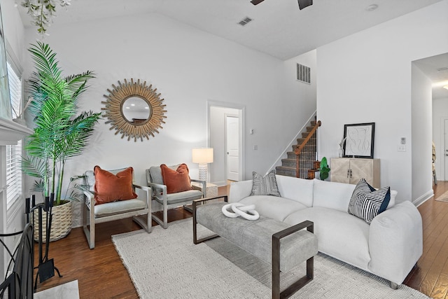 living area with visible vents, ceiling fan, stairway, and wood finished floors