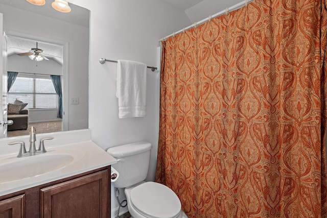 bathroom featuring ceiling fan, toilet, a shower with shower curtain, vanity, and vaulted ceiling