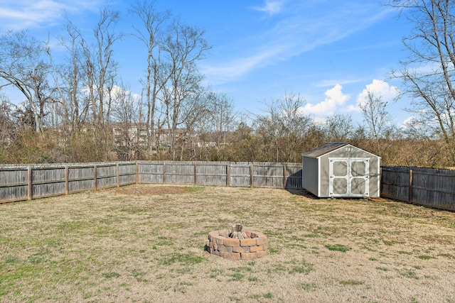 view of yard with an outdoor fire pit, an outdoor structure, a fenced backyard, and a shed