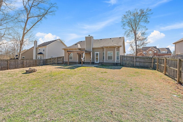 rear view of house featuring a patio, an outdoor fire pit, a fenced backyard, a lawn, and a chimney