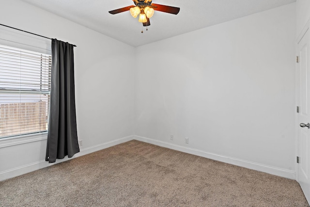 carpeted spare room with baseboards and a ceiling fan