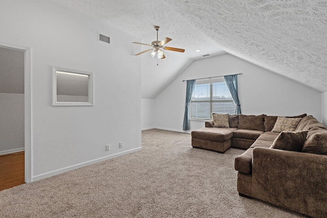 carpeted living area featuring lofted ceiling, visible vents, a textured ceiling, and baseboards