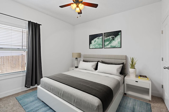 carpeted bedroom featuring baseboards and a ceiling fan