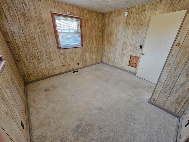 carpeted empty room with wooden walls