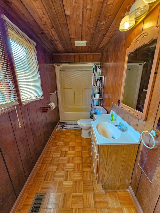 bathroom featuring vanity, wood walls, wooden ceiling, parquet floors, and toilet