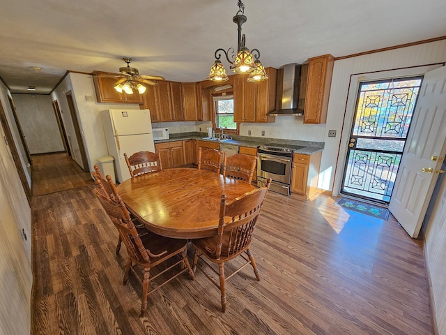 dining area featuring ceiling fan with notable chandelier, dark hardwood / wood-style floors, crown molding, and sink