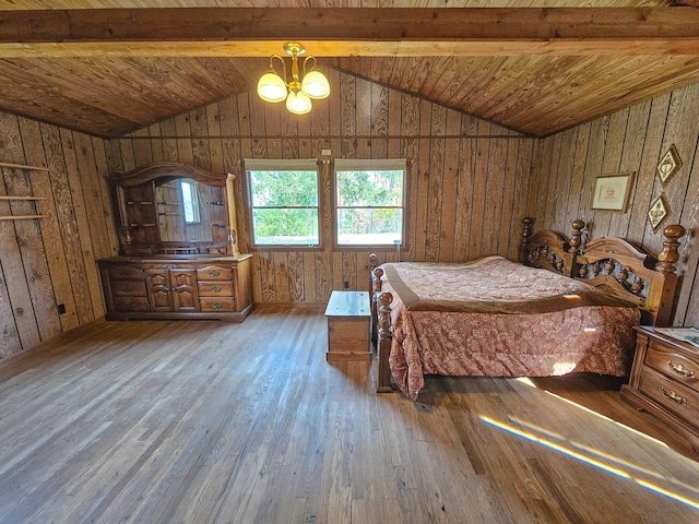 unfurnished bedroom featuring wooden walls, lofted ceiling with beams, a notable chandelier, and hardwood / wood-style flooring