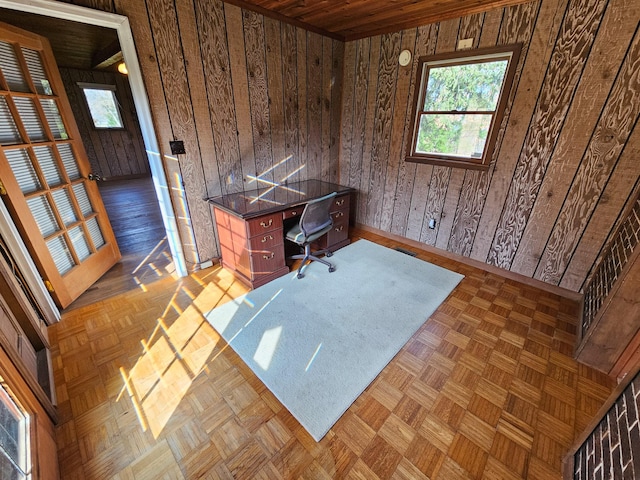 office area with dark parquet floors and wooden walls