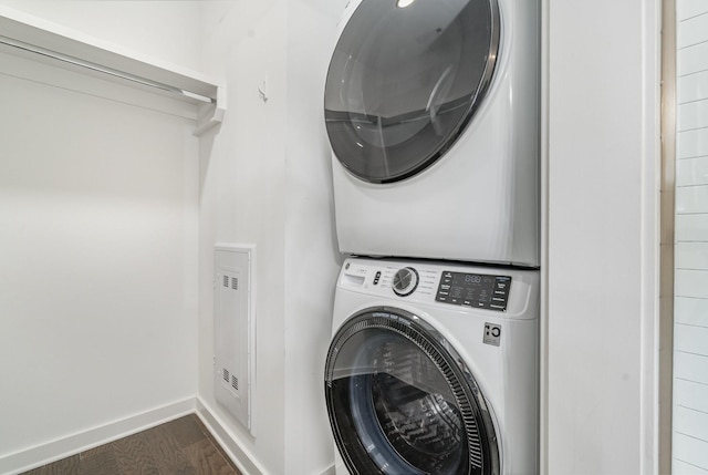 washroom featuring stacked washer / dryer and dark hardwood / wood-style floors