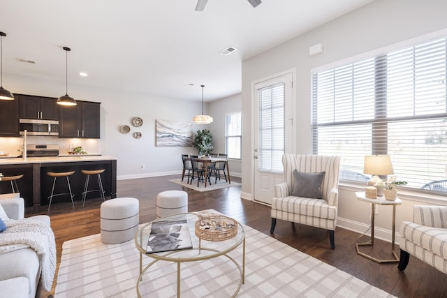 living room featuring ceiling fan and dark wood-type flooring