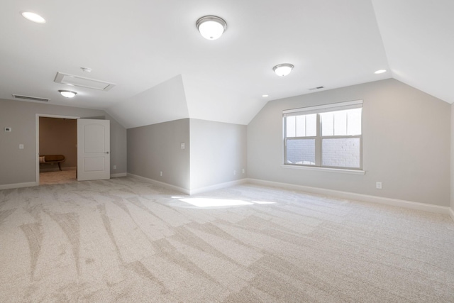 additional living space featuring light colored carpet and lofted ceiling