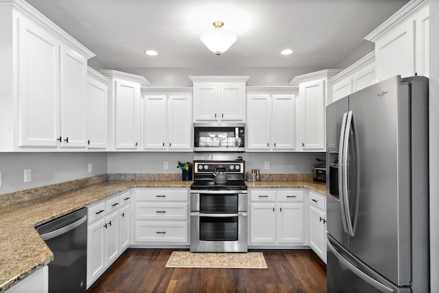 kitchen featuring dark hardwood / wood-style floors, light stone counters, white cabinetry, and stainless steel appliances