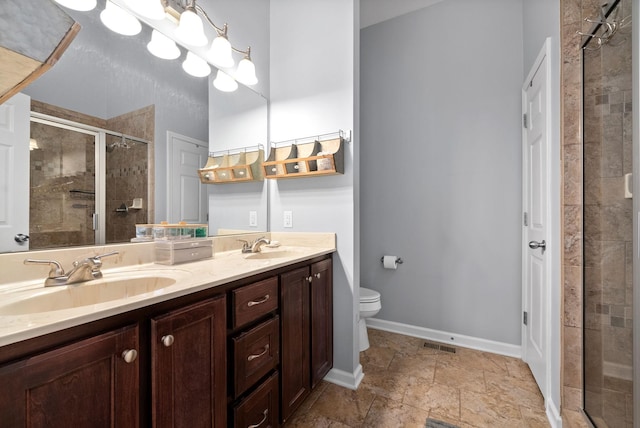 bathroom with a shower with door, vanity, and toilet