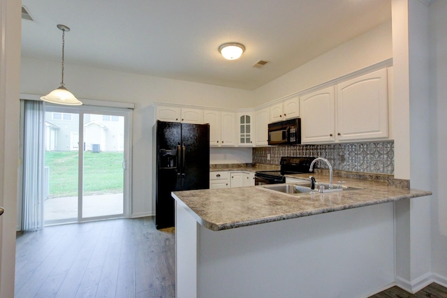 kitchen featuring white cabinetry, hanging light fixtures, tasteful backsplash, kitchen peninsula, and black appliances