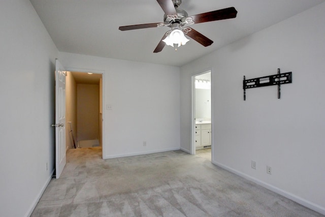 unfurnished bedroom with ensuite bath, ceiling fan, and light carpet