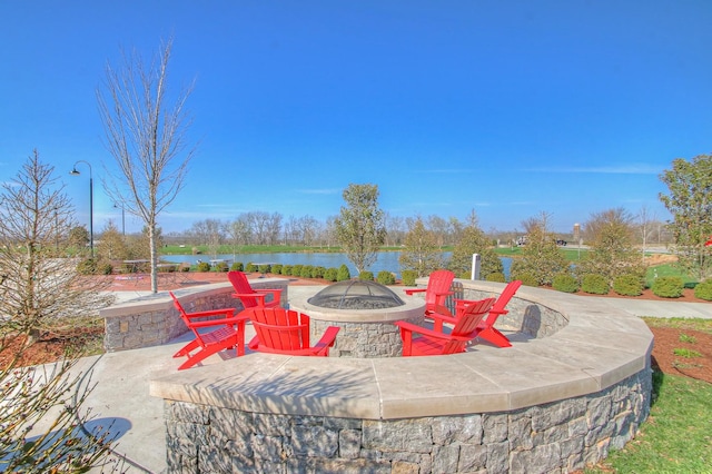 view of patio with a water view and a fire pit