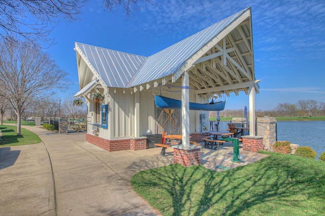 exterior space with a yard, a water view, and a patio area