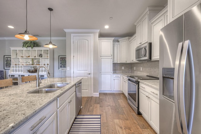 kitchen with stainless steel appliances, sink, decorative light fixtures, light hardwood / wood-style floors, and white cabinetry