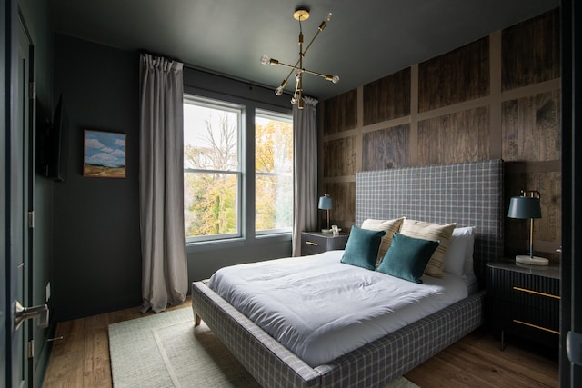 bedroom featuring wood-type flooring and a notable chandelier