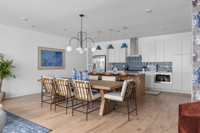 dining area with a chandelier and light wood-type flooring