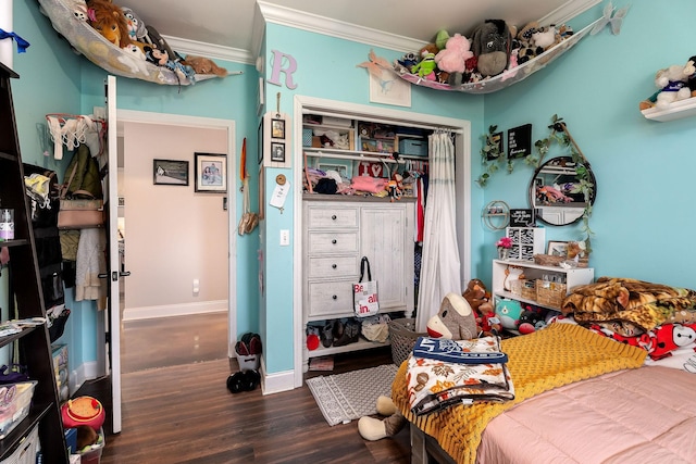 bedroom with ornamental molding, a closet, and dark wood-type flooring