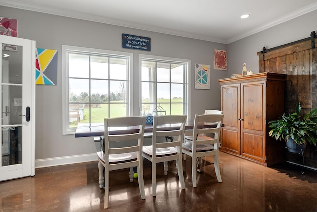 dining room with a barn door, plenty of natural light, and ornamental molding