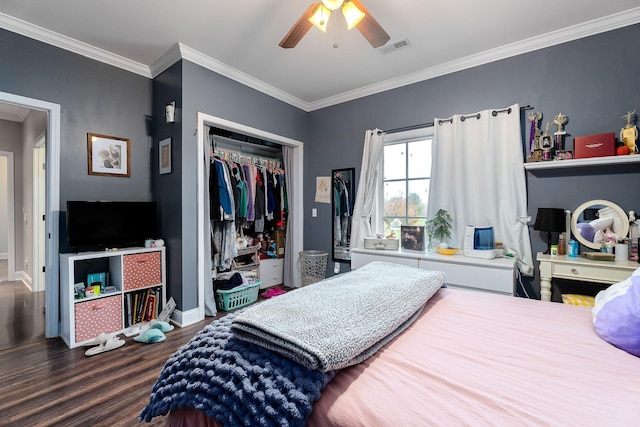 bedroom with ceiling fan, a closet, dark wood-type flooring, and ornamental molding