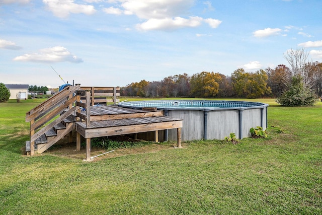 view of pool with a wooden deck and a lawn