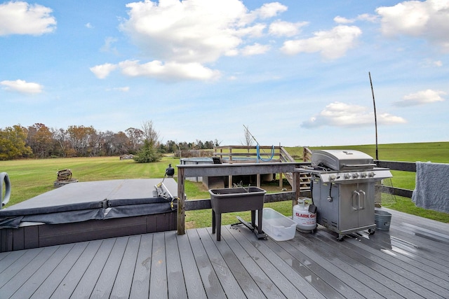 wooden deck with a lawn, grilling area, and a covered hot tub