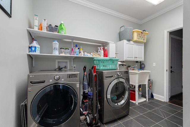 laundry area with washing machine and dryer, dark tile patterned floors, cabinets, and ornamental molding