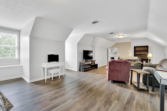 living room featuring dark hardwood / wood-style flooring, lofted ceiling, and a textured ceiling