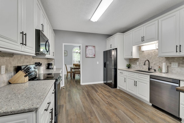 kitchen featuring a textured ceiling, sink, black appliances, wood-type flooring, and white cabinetry