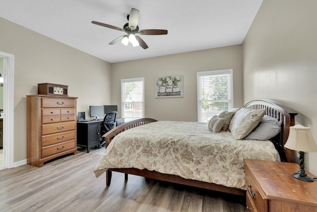 bedroom featuring multiple windows, ceiling fan, and light hardwood / wood-style floors