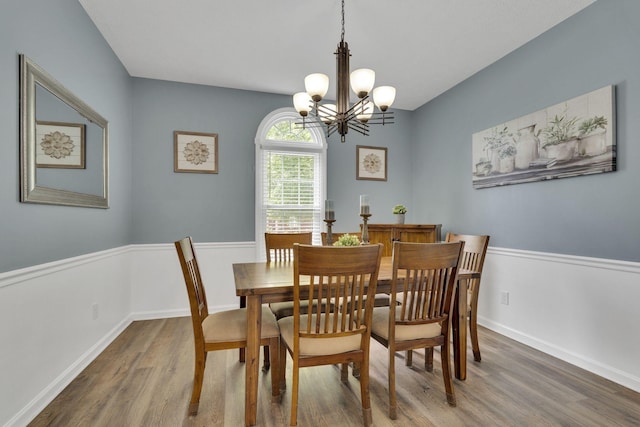 dining space featuring hardwood / wood-style floors and a notable chandelier