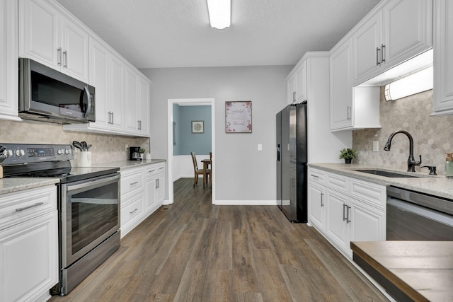 kitchen featuring white cabinetry, sink, stainless steel appliances, and dark hardwood / wood-style floors