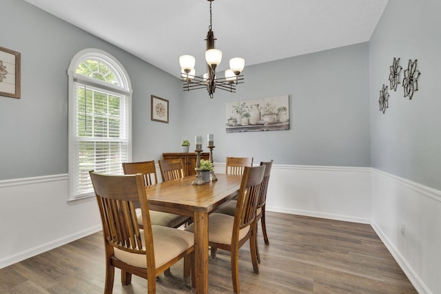 dining area with a notable chandelier and dark hardwood / wood-style flooring