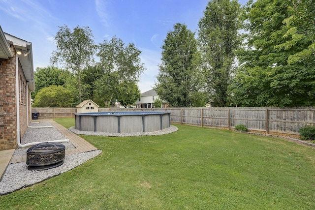 view of yard with a fenced in pool and an outdoor fire pit