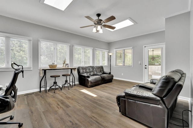 living room with hardwood / wood-style floors, ceiling fan, a healthy amount of sunlight, and crown molding