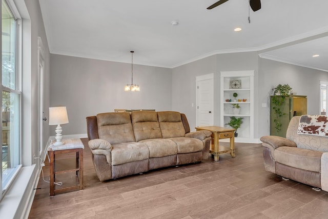 living room with light hardwood / wood-style flooring, a wealth of natural light, and ornamental molding