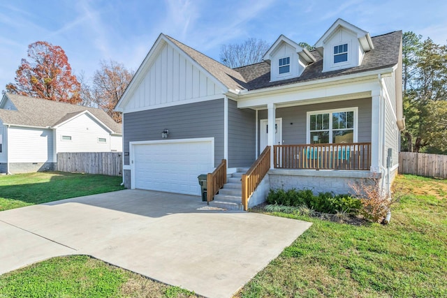 view of front facade featuring a porch, a garage, and a front lawn