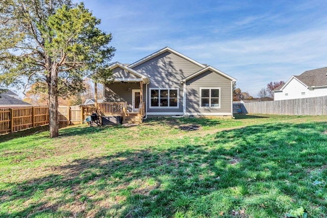 rear view of property with a deck and a yard