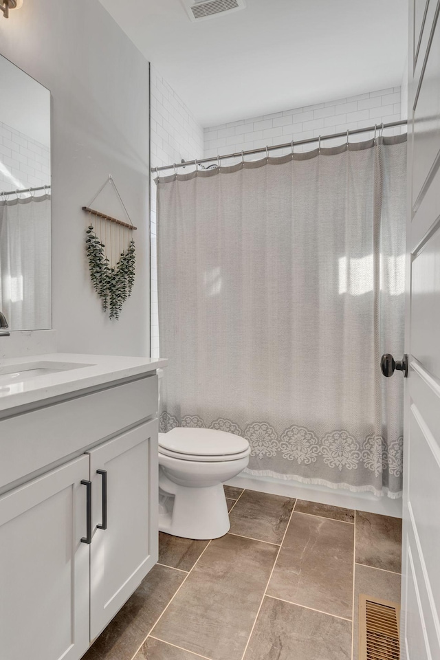 full bathroom featuring tile patterned floors, shower / bath combo with shower curtain, vanity, and toilet