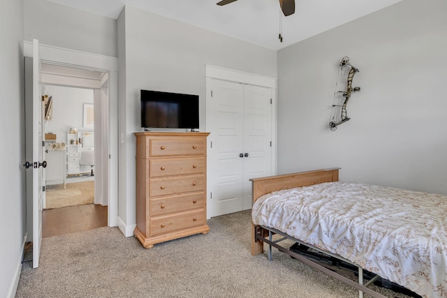 carpeted bedroom with ceiling fan and a closet